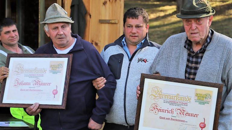 Johann "Hansl" Maurer und Heinrich "Josef" Neuner wurden von Obmann Manfred Krug für ihre Verdienste um den Verein der Schafbader in Fiecht geehrt. Foto: Knut Kuckel